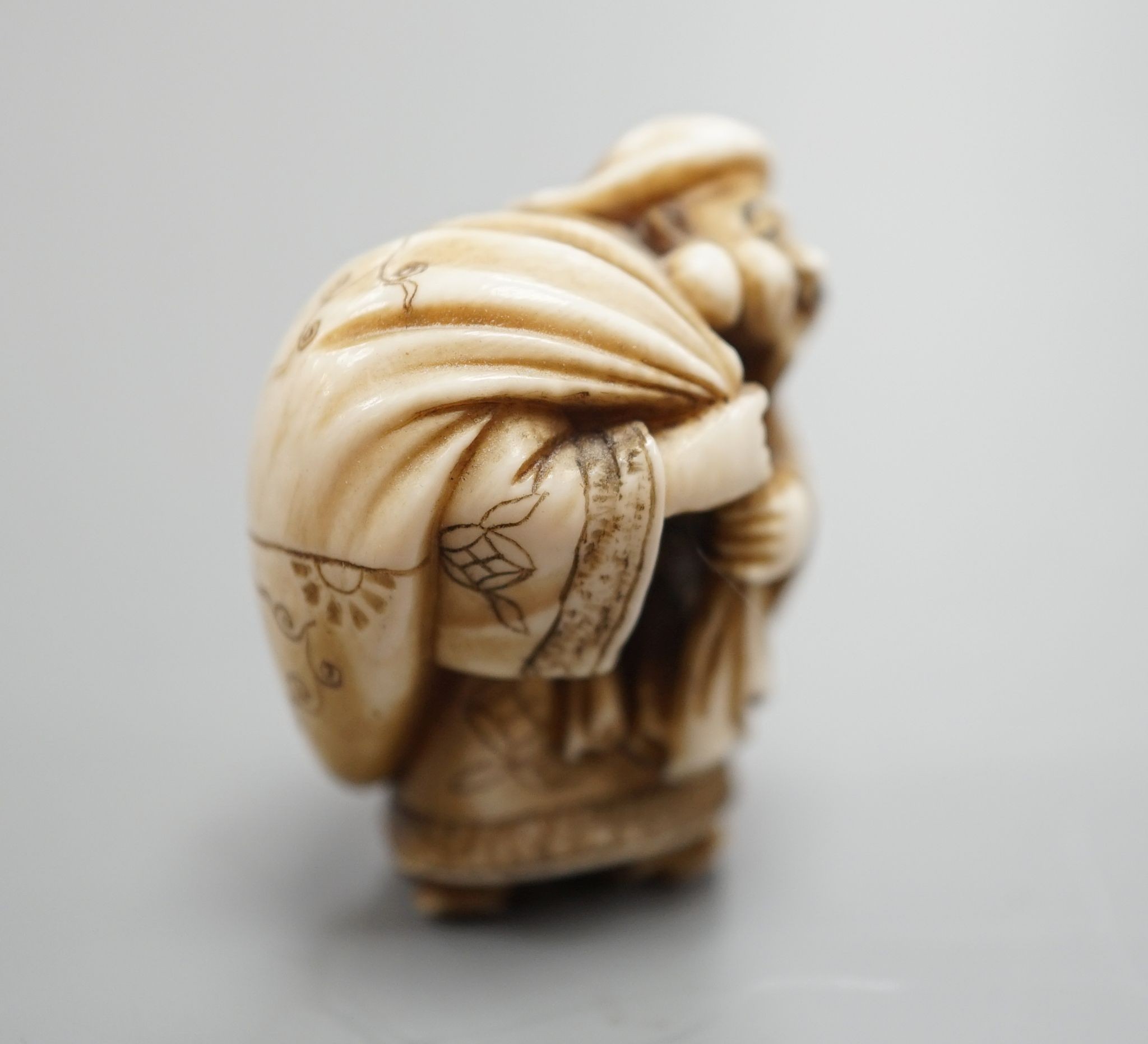 A Japanese ivory netsuke of Daikoku or Ebisu, Meiji period, 4 cms high.